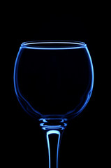 Wineglass consecrated by silhouette light with reflection on a black background