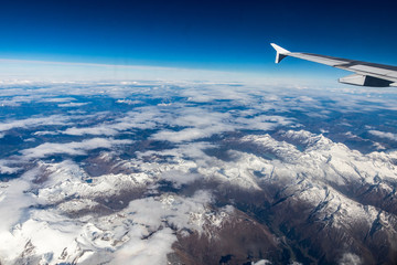 Fototapeta premium wing of an airplane flying above the clouds
