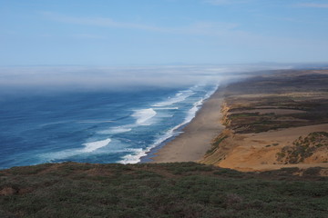 Waves breaking on the beach at Point Reyes National Seashore in Northern California, with fog...