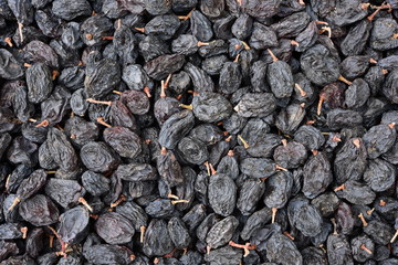 Black dried grapes on a white background