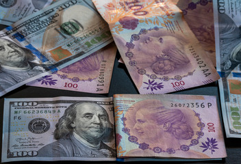 Billetes de cien pesos argentinos. Dólares. Argentina. Crisis económica. Devaluación