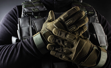 Warrior soldier in tactical gloves standing front view closeup. - obrazy, fototapety, plakaty