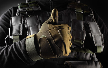 Soldier in tactical gloves showing like gesture front view closeup.