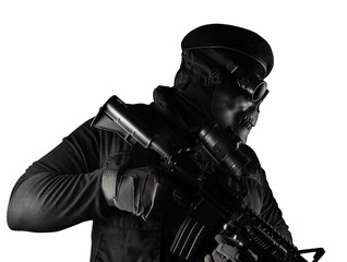Isolated soldier in skull mask, rifle, glasses and beret side view.