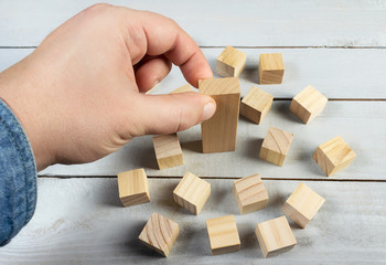 Hand putting a wooden block concept photo.