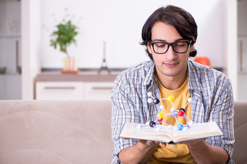 Young student physicist preparing for exam at home    