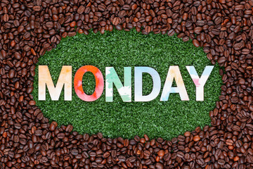 Close up of word monday on grass with coffee beans around