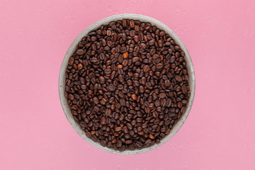 Obraz na płótnie Canvas Close up of cup of coffee beans on pink background