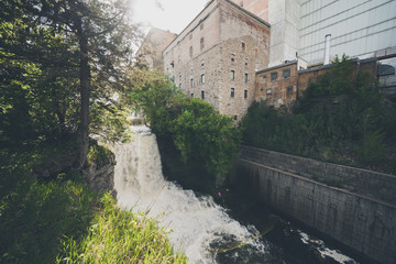 Fototapeta na wymiar Vermillion Falls, an urban waterfall next to an old factory located in Hastings, Minnesota
