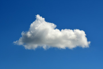Naklejka na ściany i meble Single fluffy white cloud floats in middle of clear blue sky.