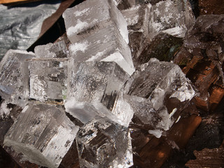 Giant ice cubes being cut down to smaller squares for drinks at the bar.