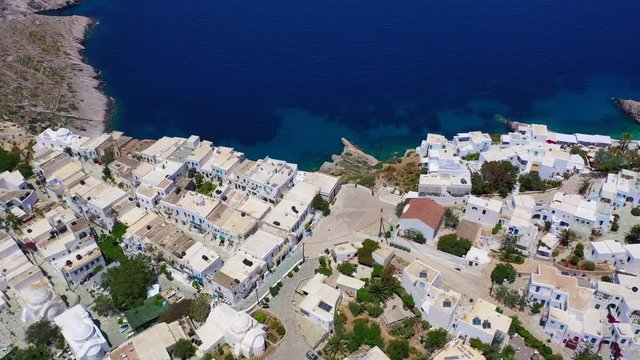 Aerial drone video of iconic and picturesque main village (chora) of Folegandros island featuring castle and built on top of steep hill overlooking the Aegean blue sea, Cyclades, Greece