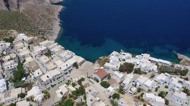 Aerial drone video of iconic and picturesque main village (chora) of Folegandros island featuring castle and built on top of steep hill overlooking the Aegean blue sea, Cyclades, Greece