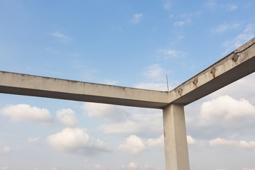 Frame structure of modern building concrete pillars under blue sky and white clouds background