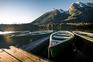 Colorful summer sunrise on the Hintersee lake with white pleasure launches.