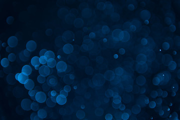 Glitter lights abstract dark blue background. Defocused bokeh dark illustration