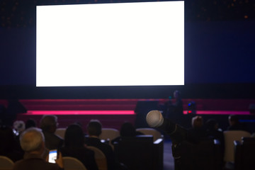 Business people looking at empty digital screen on stage in seminal room