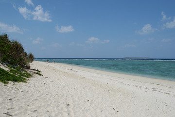 夏の青空とエメラルドグリーンの海と白い砂浜