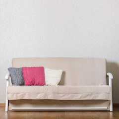 Beige sofa with colorful pillows (pink, grey, white) in the living room.