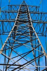 high-voltage towers of power lines against the blue sky