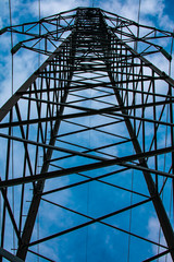 high-voltage towers of power lines against the blue sky