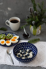 A healthy and nutritious breakfast: a bowl of cottage cheese with blueberries, a small bowl of prune jam, a plate of hardboiled eggs, baguette slices with avocado and blue cheese,