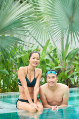 Couple relaxing in hotel swimming pool
