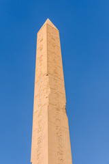 Granite obelisk against blue sky in a Karnak temple. Luxor, Egypt.