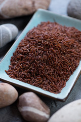 Close-up of uncooked red kernel rice, selective focus, vertical shot