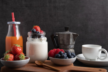 A serving of yogurt with fresh fruit on a breakfast table