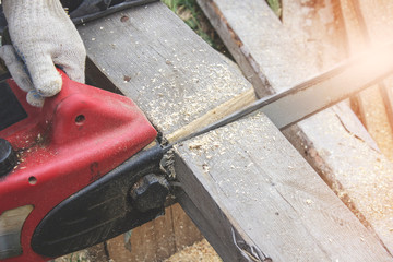 The Builder saws a gray old Board