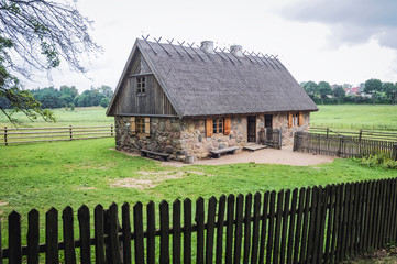 Example of 19th century stone cottage with thatched roof in heritage park in Olsztynek town of Olsztyn County in Warmia-Mazury Province, Poland