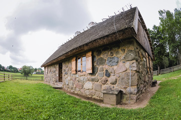 Fototapeta na wymiar Example of 19th century stone cottage with thatched roof in heritage park in Olsztynek town of Olsztyn County in Warmia-Mazury Province, Poland