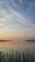 Obraz premium Sunset over the lake. Cloudy sky over calm water surface.