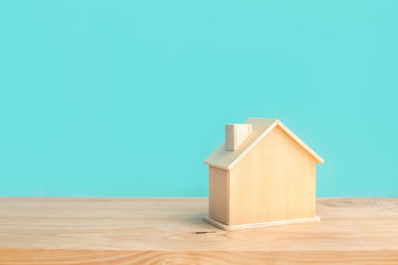Obraz na płótnie Canvas Mockup of house(home) made by wood with blue pastel color on wood table background.Property and estate or investment concepts