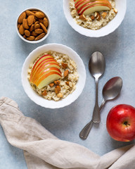 Healthy breakfast Oatmeal porridge with apples and nuts served in a bowl.