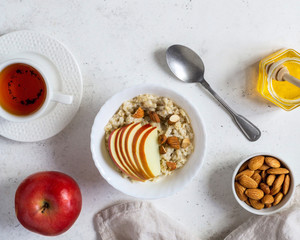 Healthy breakfast Oatmeal porridge with apples and nuts served in a bowl.