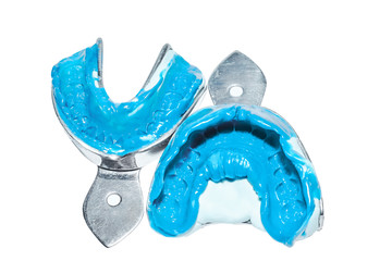 Two dental impressions on a white background. Dental molds from the upper and lower jaws of silicone material. The imprint of the tooth row of high precision.