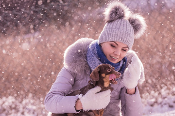Obraz premium Woman playing with dog during winter