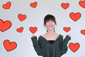 Love concept- portrait of long black hair young asian woman wearing green dress making a wish and smiling with red heart illustration doodle icon at the back ground