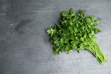 Bunch of fresh green parsley on grey background, view from above. Space for text