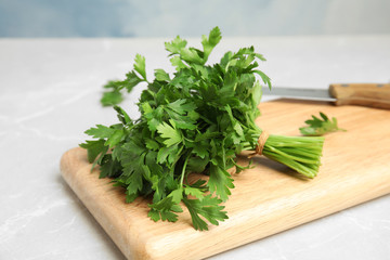 Wooden board with fresh green parsley on table, closeup