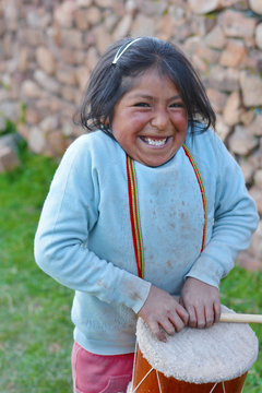 Little native american girl playing traditional sikuri drum.
