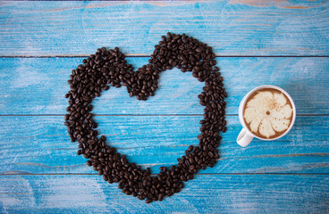 roasted coffee beans placed on an old blue wooden floor,top view coffee cup for background,Concept:ingredient mocha breakfast drink food fresh