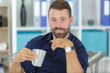 handsome man holding a cup of coffee