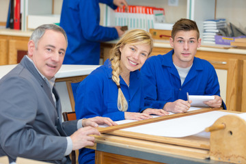 Fototapeta premium carpenter and woodworking apprentice making drawing designs