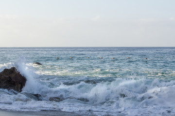 splashing wave breaking on rock, with swirling foam from breaking wave and returning backwash