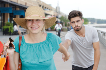 Obraz premium woman pulling boyfriend into store