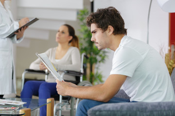 man using smartphone in hospital waiting area