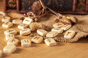 Fototapeta na wymiar Handmade scandinavian wooden runes on a wooden vintage background. Concept of fortune telling and prediction of the future.